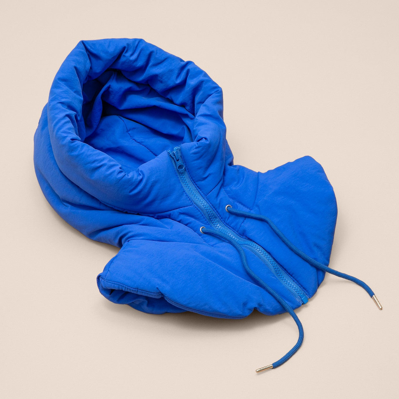 Blue puffer hood on a beige background