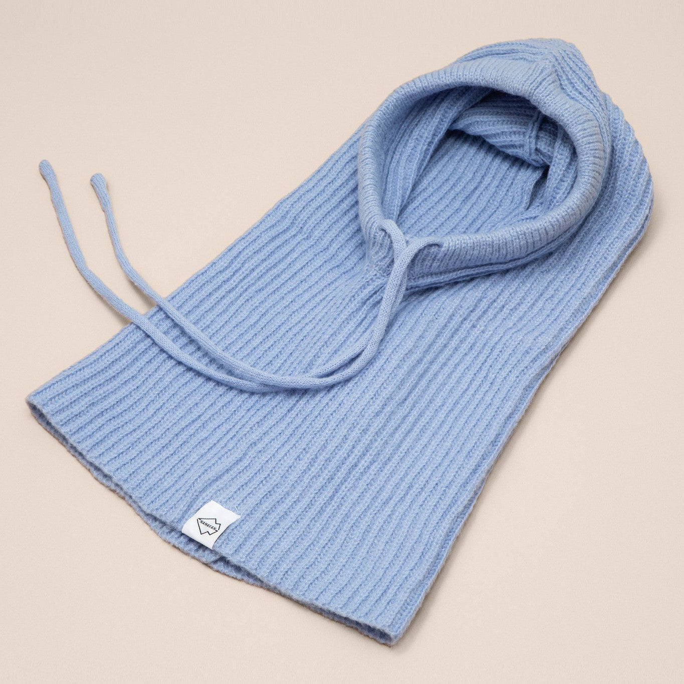 Blue knitted hood on a beige background